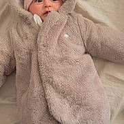 Lylia participe au concours pour gagner de l'argent avec cette photo : baby, child, infant, hood, hat, clothing, fluffy, warm, bed, blanket, fur, cute, portrait, lying_down, indoors, soft, apparel, face, wide_eyes, winter