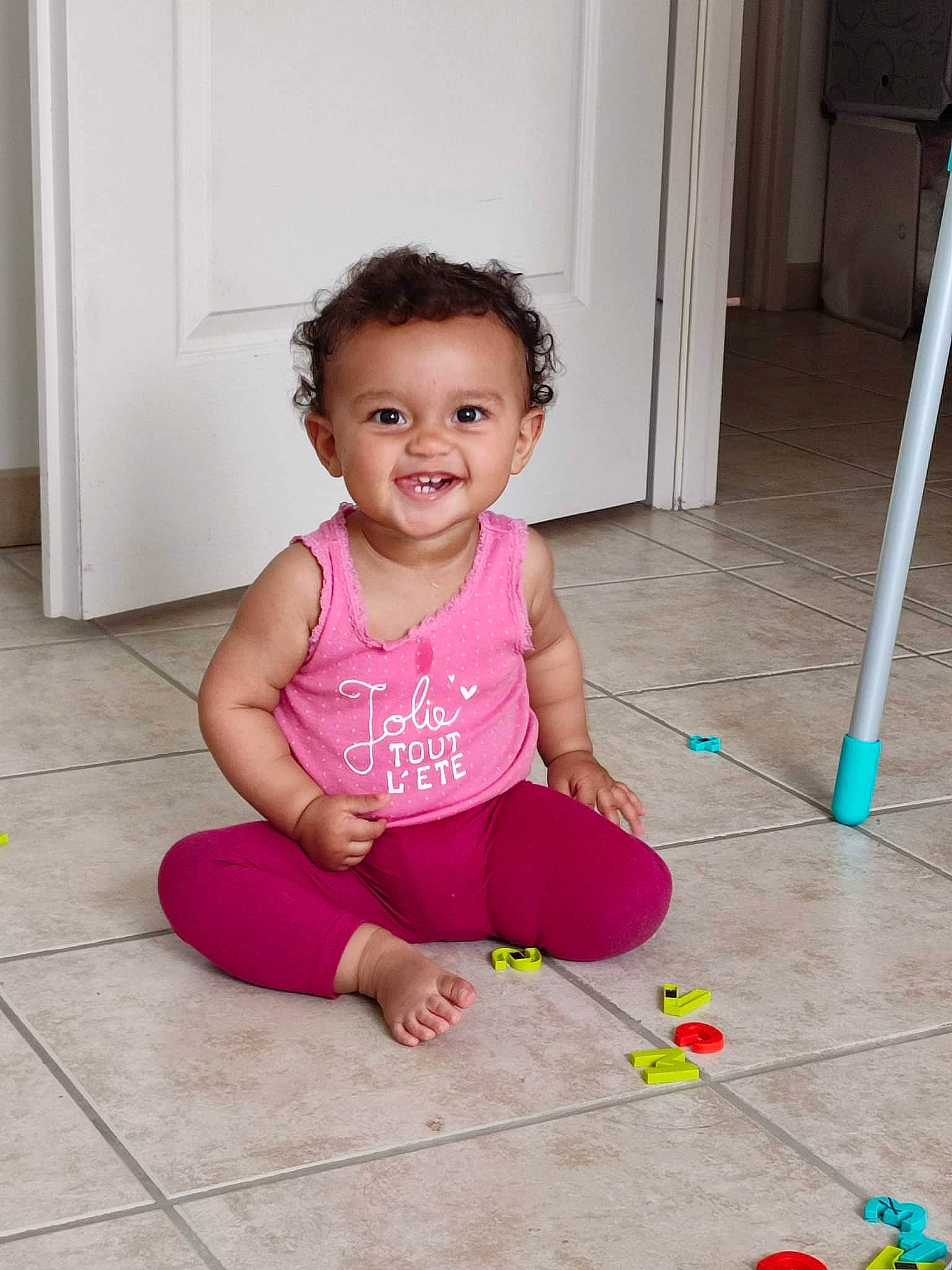 Amélia a rejoint le concours — aidez-le/la à gagner de superbes lots ! baby, baby_toddler_clothing, cheek, child, door, face, facial_expression, floor, flooring, fun, happy, hardwood, head, joy, magenta, person, pink, skin, sleeve, smile