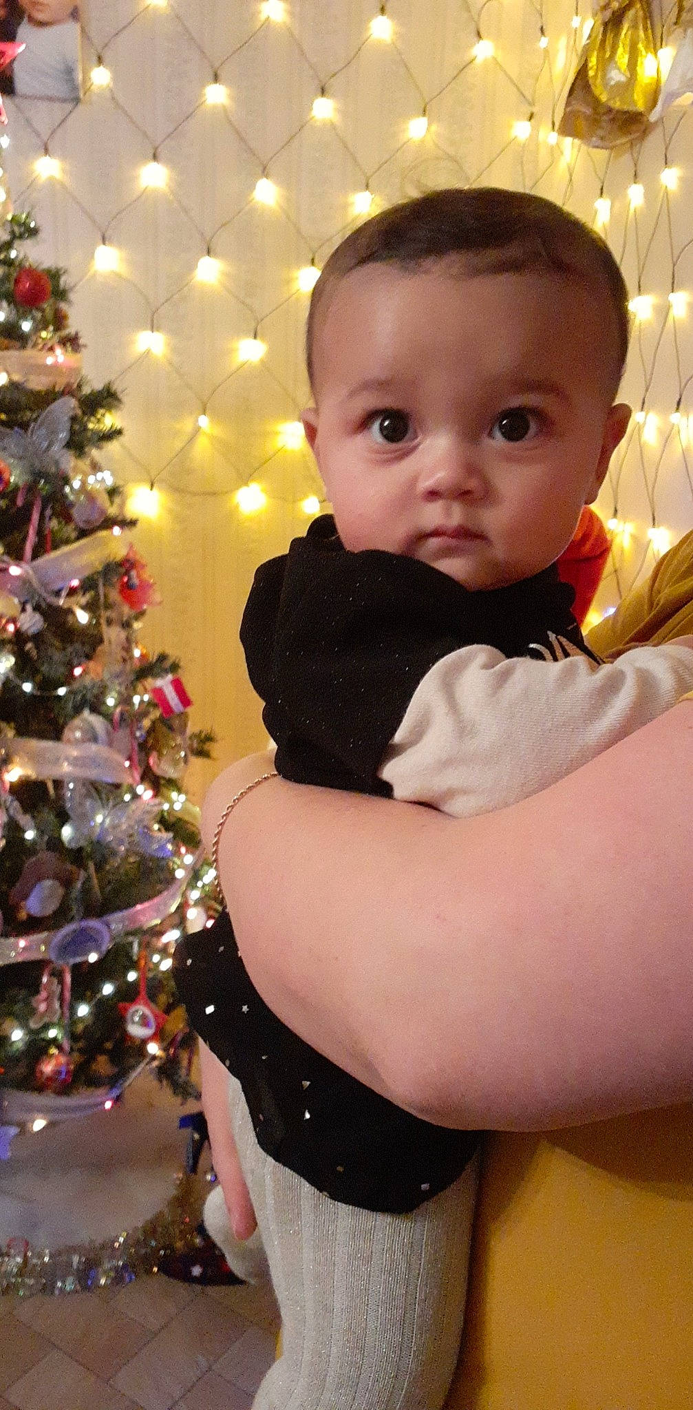 Amélia a rejoint le concours — aidez-le/la à gagner de superbes lots ! arm, baby, baby_toddler_clothing, cheek, christmas_ornament, christmas_tree, eye, facial_expression, fun, hair, hairstyle, happy, holiday_ornament, human_body, ornament, person, plant, sleeve, standing, toddler