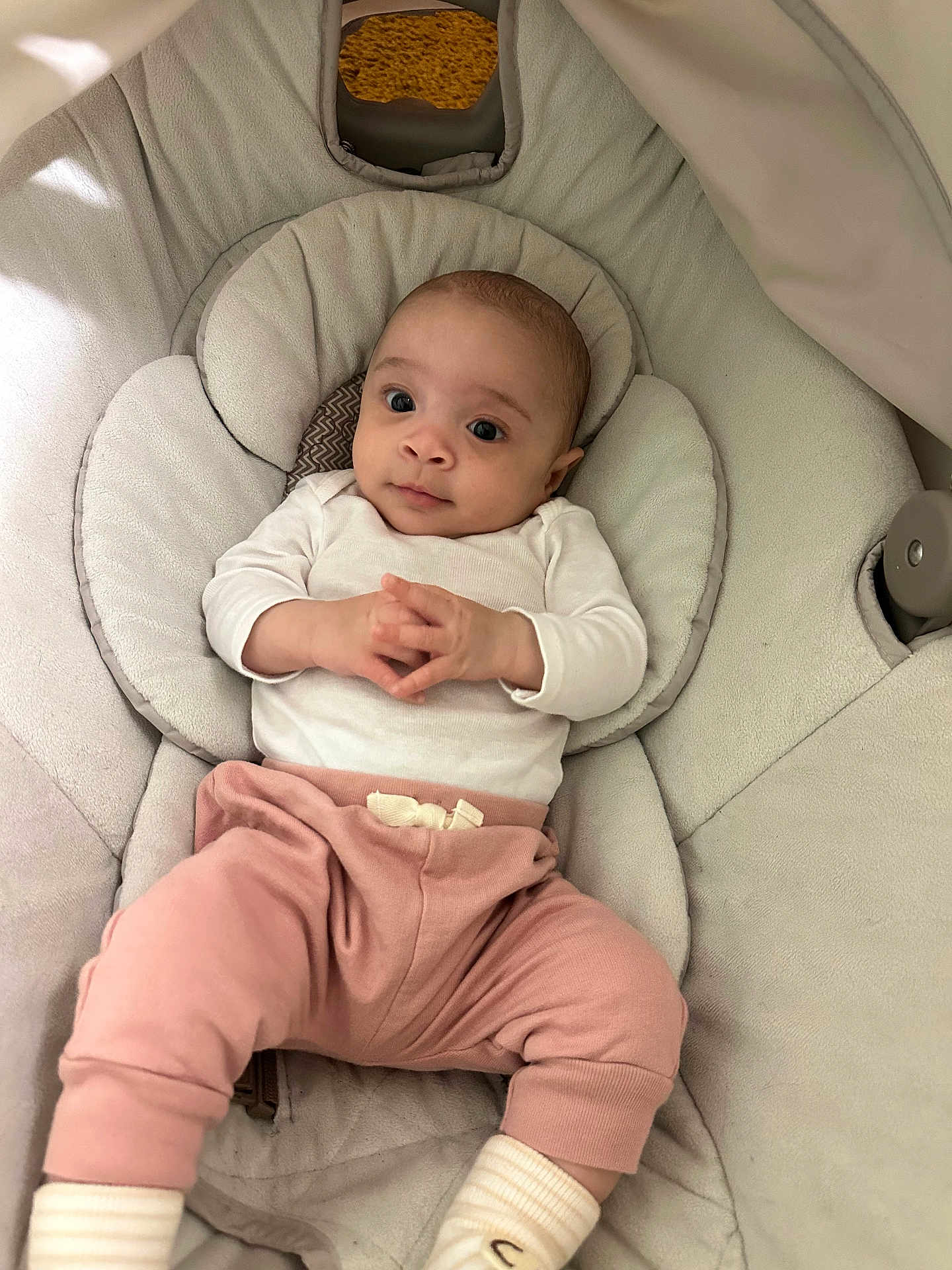 Elani is registered to the contest to win money with this photo: baby, infant, child, baby_seat, cushion, white_shirt, pink_pants, socks, indoor, portrait, cute, hands, clothing, person, young_child, resting, looking_up, comfort, soft, seat