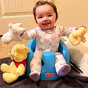 Rhiley is registered to the contest to win money with this photo: baby, blue_chair, carpet, child, duck_toy, family_photo, happy, home, indoor, infant, onesie, playroom, portrait, rainbow_pattern, sitting, smiling, stuffed_animal, teddy_bear, toy, unicorn_toy
