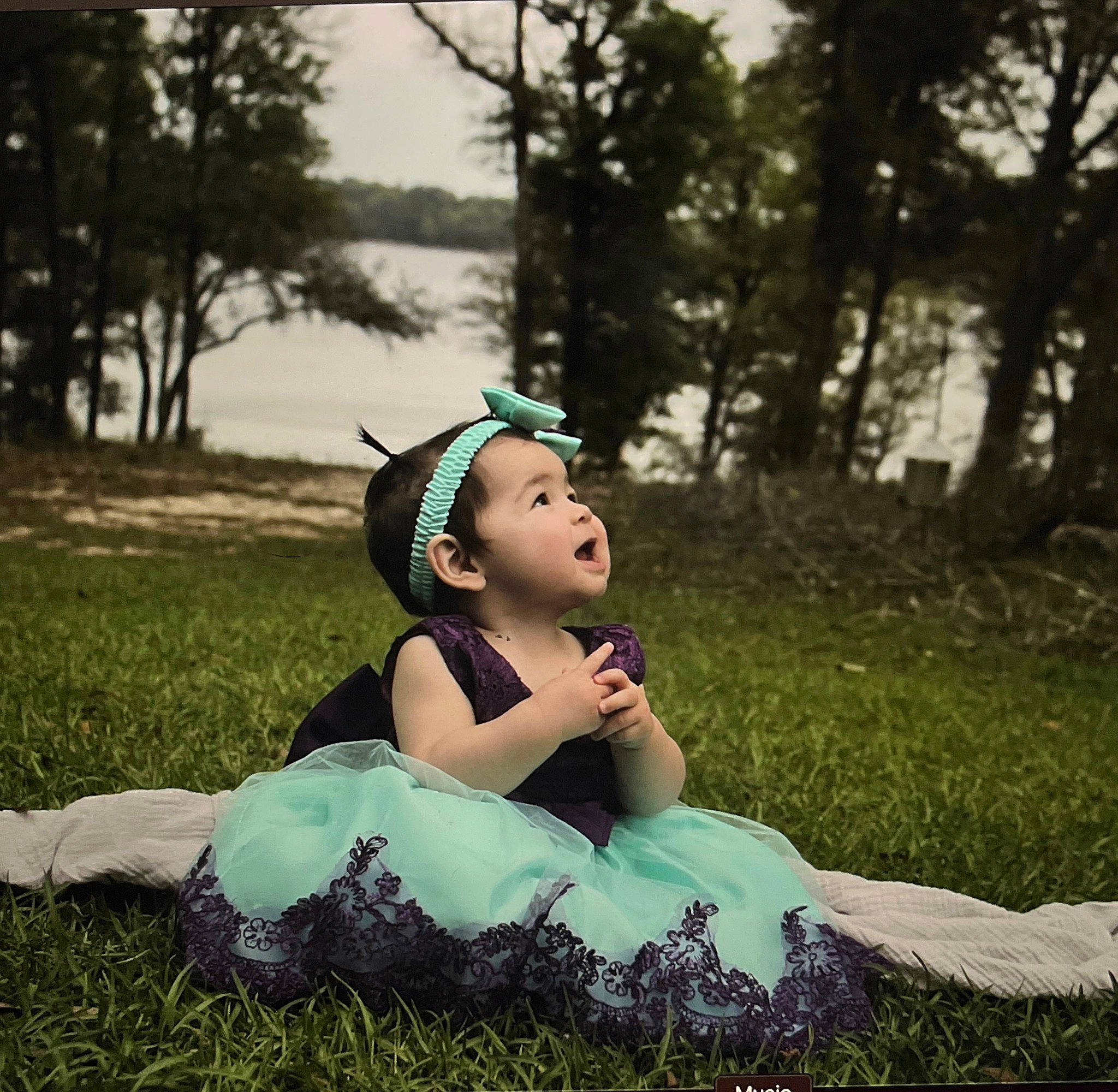 Mia is registered to the contest to win money with this photo: blond, brown_hair, cap, eyewear, flash_photography, forest, grass, grassland, happy, headpiece, landscape, lawn, leisure, meadow, people_in_nature, person, plant, sitting, sunlight, tints_and_shades
