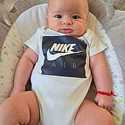 Jack joined the competition — help win amazing prizes! baby, infant, onesie, clothing, nike_air, red_bracelet, baby_seat, cushion, star_pattern, face, skin, arms, legs, indoor, portrait, cute, child, person, comfort, expression