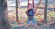 Joshua joined the competition — help win amazing prizes! baby, backyard, blue_clothing, child, colorful_clothing, daytime, face, fallen_leaves, nature, outdoor, playground, playtime, portrait, sitting, standing, sunlight, swing, toddler, tree_trunk, trees