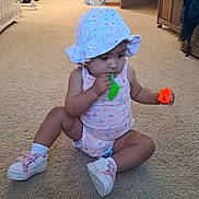 Ivy'Ann is registered to the contest to win money with this photo: toddler, child, balloon, hat, carpet, indoor, footwear, toy, sandal, pink, polka_dot, sitting, curious, home, living_room, door, plastic_bag, colorful, floor, person
