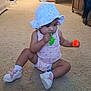 toddler, child, balloon, hat, carpet, indoor, footwear, toy, sandal, pink, polka_dot, sitting, curious, home, living_room, door, plastic_bag, colorful, floor, person