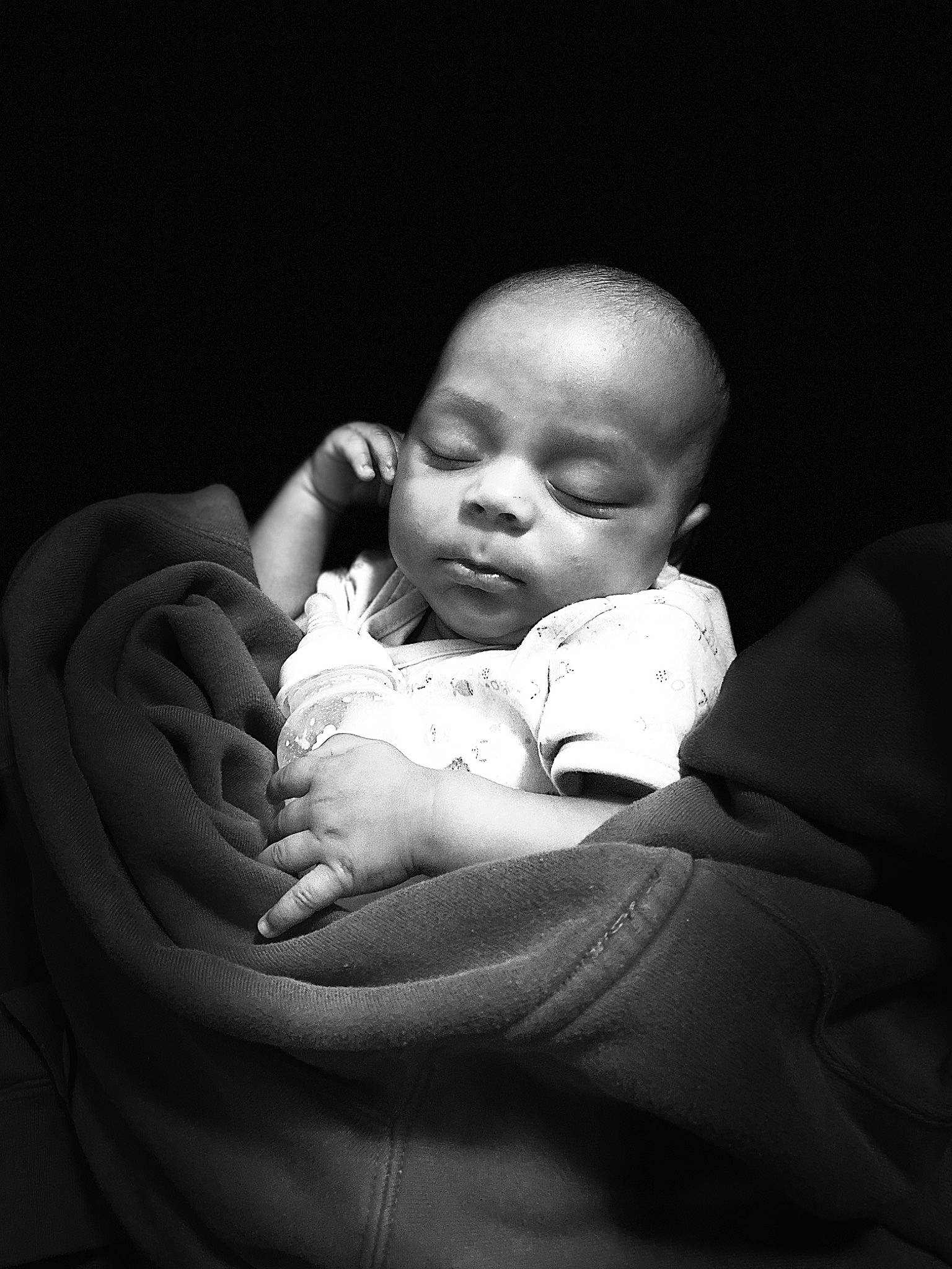 Amir is registered to the contest to win money with this photo: baby, baby_toddler_clothing, cheek, chin, close_up, comfort, darkness, elbow, flash_photography, fun, gesture, hand, happy, iris, monochrome, monochrome_photography, mouth, nose, person, skin