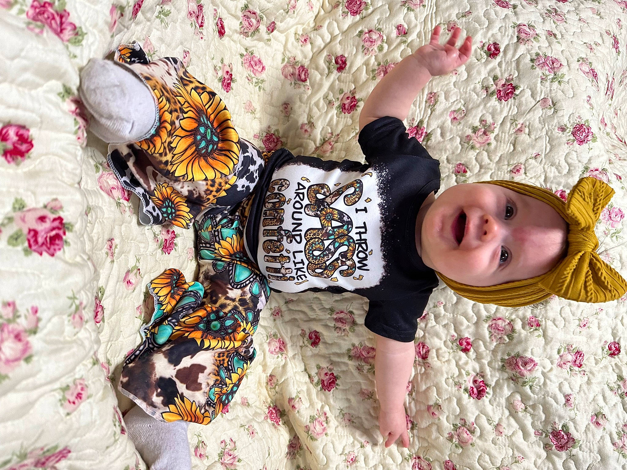 Maggie is registered to the contest to win money with this photo: baby, baby_toddler_clothing, child, comfort, dress, happy, leisure, linens, pattern, person, plant, play, room, sleeve, smile, textile, toddler, tree, visual_arts, wood