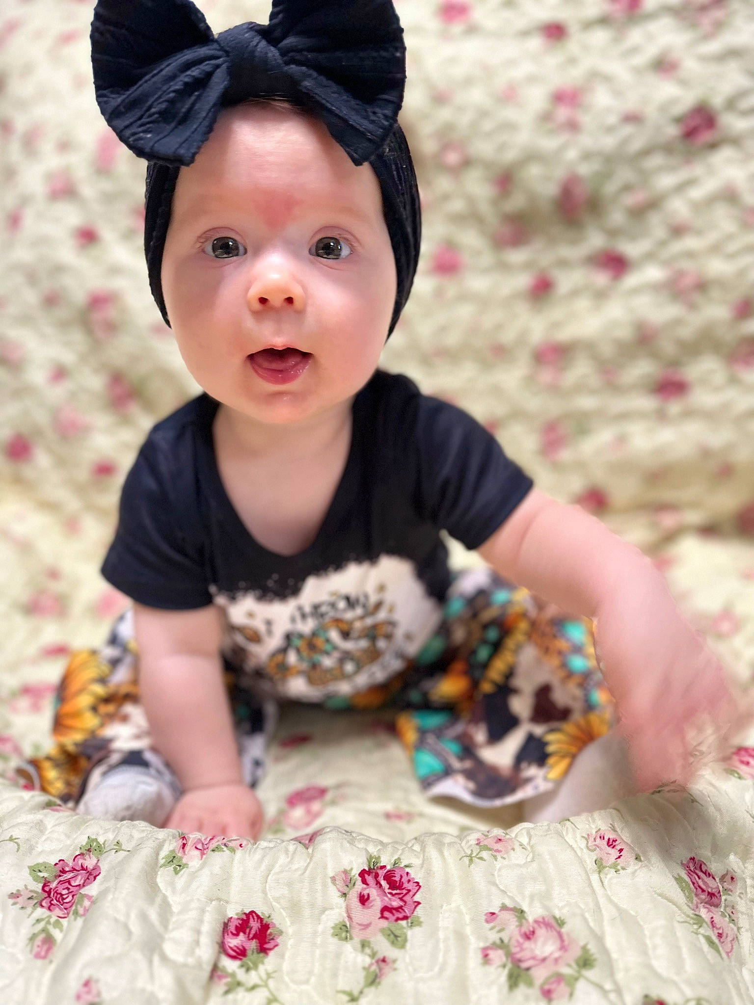 Maggie is registered to the contest to win money with this photo: baby, baby_products, baby_toddler_clothing, cap, child, costume_hat, face, fashion_accessory, happy, hat, linens, pattern, person, pink, sitting, skin, sleeve, sun_hat, surprise, t_shirt