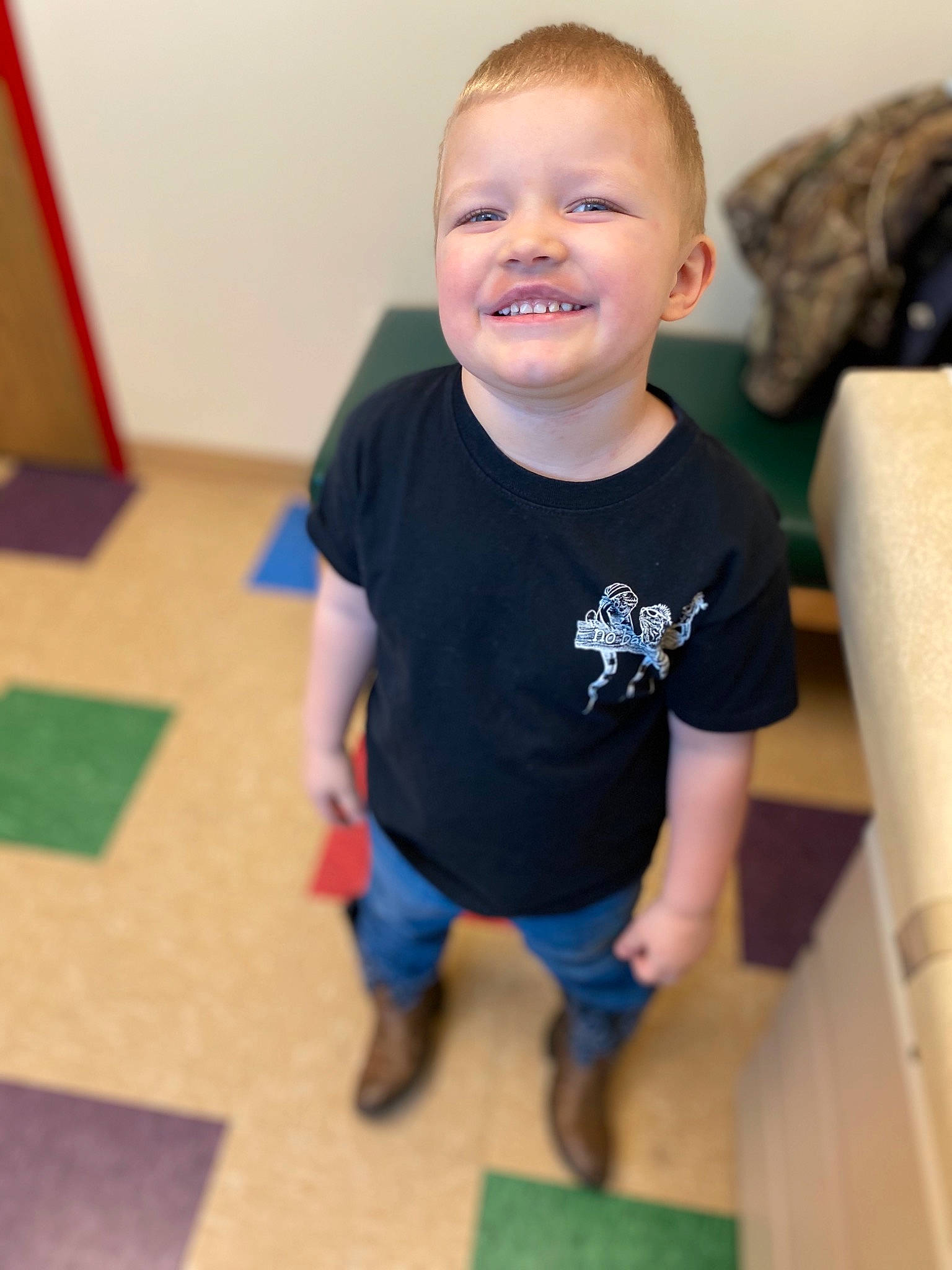 Gannon is registered to the contest to win money with this photo: arm, baby, child, face, floor, flooring, head, joint, joy, leg, person, play, room, sitting, smile, standing, t_shirt, toddler, vacation