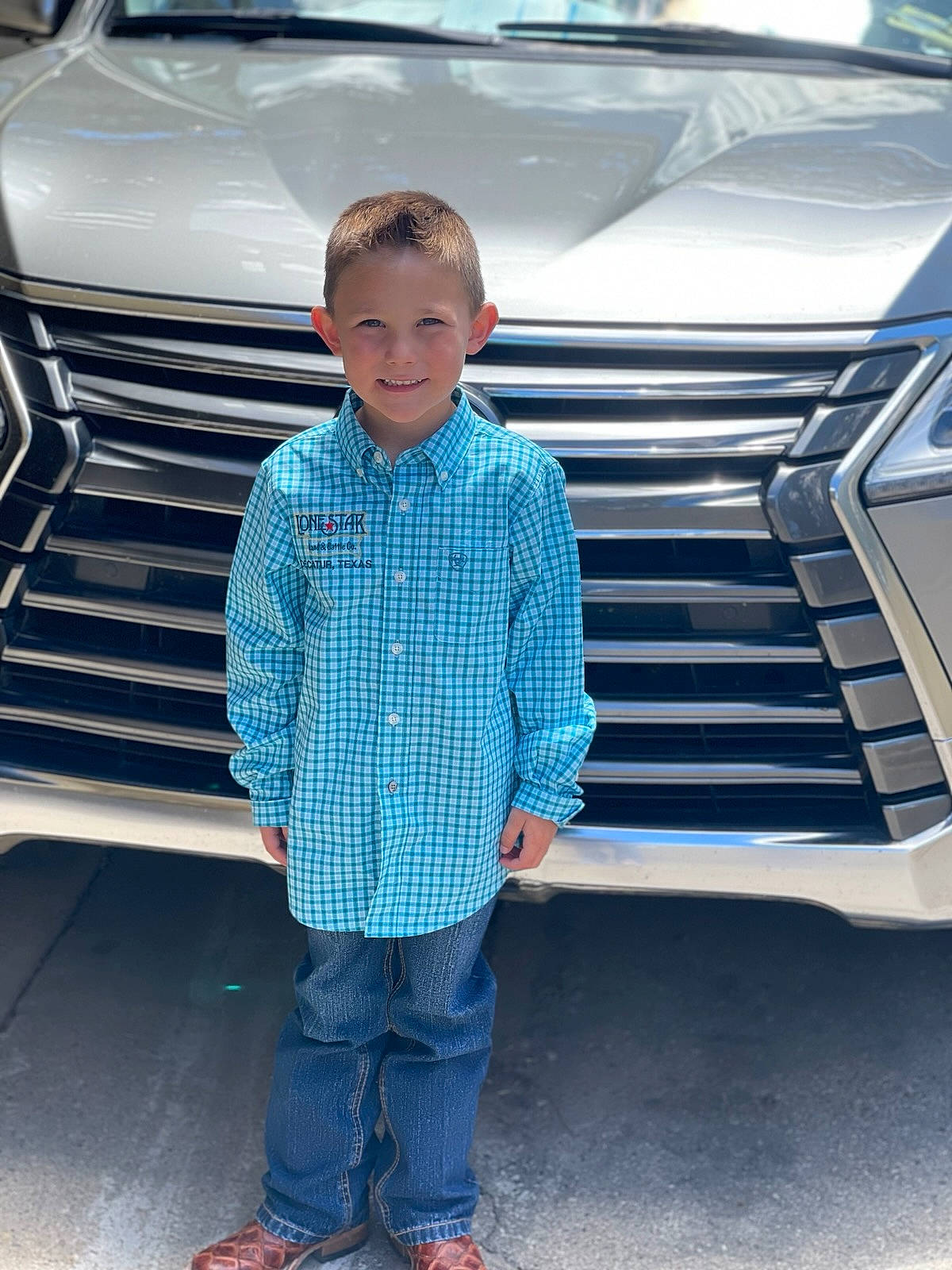 Kace is registered to the contest to win money with this photo: automotive_design, automotive_exterior, automotive_lighting, automotive_tire, bumper, car, cool, denim, electric_blue, grille, hood, joy, motor_vehicle, person, rolling, shoe, smile, sneakers, standing, t_shirt