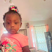 Angelia joined the competition — help win amazing prizes! toddler, child, indoor, living_room, pink_shirt, bow, minnie_mouse, curious, furniture, curtains, table, sofa, patterned, casual_clothing, portrait, person, young_child, home, cute, girl