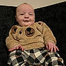 Draven joined the competition — help win amazing prizes! baby, child, smile, sitting, couch, clothing, bear_sweater, checkered_pants, furniture, indoor, cute, happy, infant, portrait, young_child, warm_clothing, cozy, person, face, hands