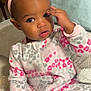 toddler, child, onesie, headband, pink, gray, leopard_print, bed, pillow, hand, face, eye, hair, cozy, indoor, cute, baby, sitting, expression, soft_lighting