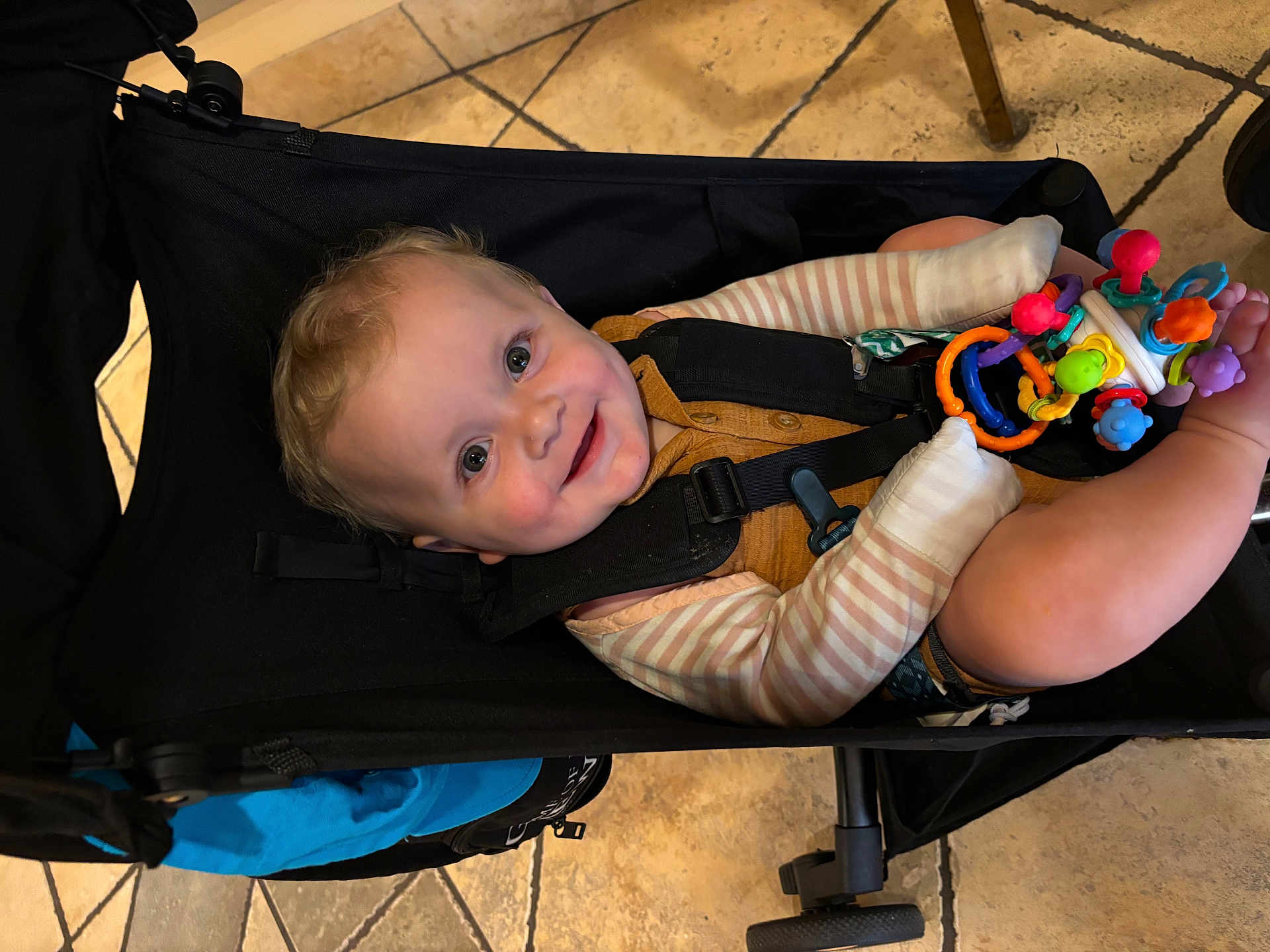 Lincoln joined the competition — help win amazing prizes! baby, child, stroller, toy, smile, happy, indoor, floor, clothing, seatbelt, person, cute, infant, play, colorful, legs, face, head, expression, young