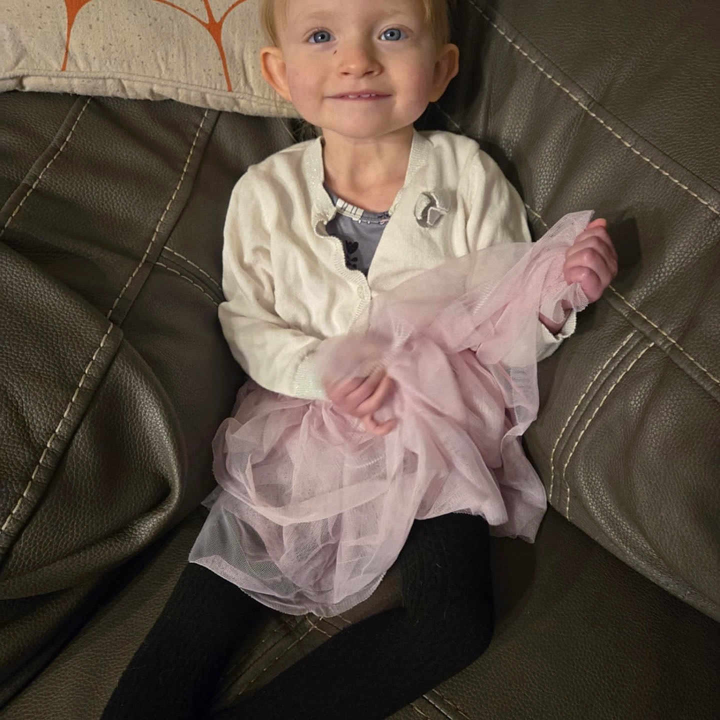 Gracelynn is registered to the contest to win money with this photo: blonde, child, clothing, coat, couch, cushion, face, female, furniture, girl, hair, happy, head, homedecor, pants, person, photography, portrait, sitting, smile