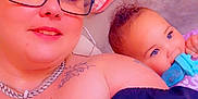 Aurorah joined the competition — help win amazing prizes! baby, blue_eyes, candid, casual, chewing, child, curly_hair, face, glasses, heart, indoor, jewelry, necklace, person, portrait, purple_clothing, smile, tattoo, toy, woman