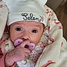 Selene is registered to the contest to win money with this photo: newborn, baby, infant, portrait, face, eyes, pacifier, hat, bunny_ears, blanket, swaddled, clothing, hand, fingers, floral_pattern, pink, purple, indoors, close_up, sleepwear