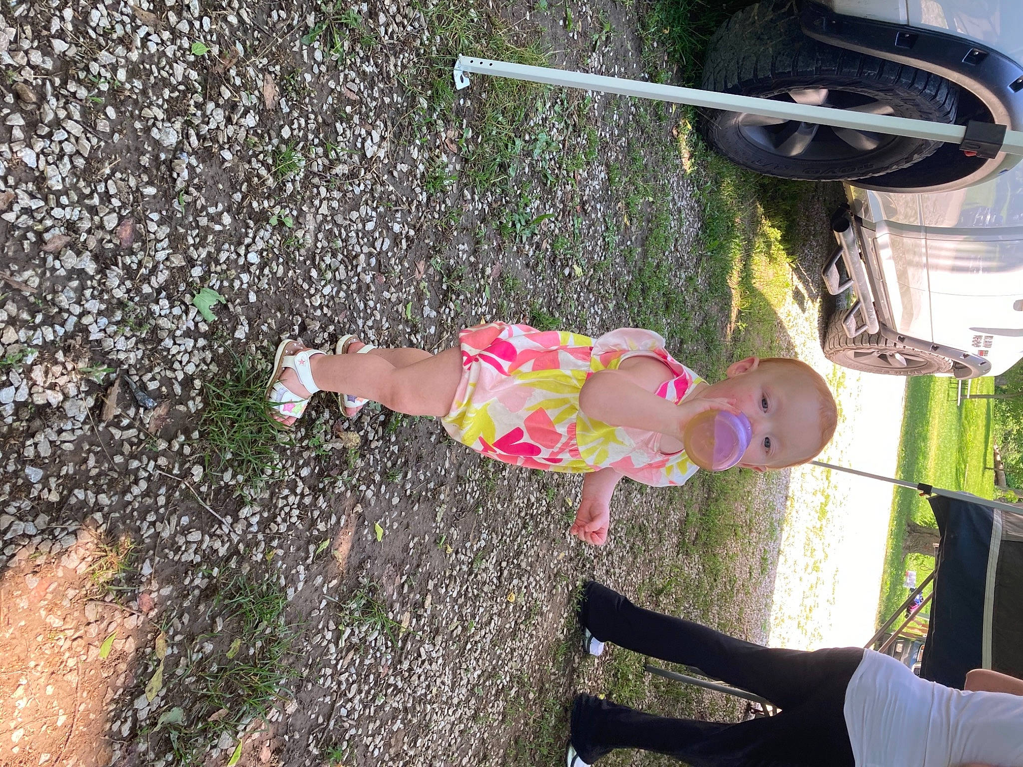 Rylah is registered to the contest to win money with this photo: asphalt, automotive_tire, automotive_wheel_system, fun, grass, human_leg, knee, leisure, people_in_nature, person, plant, recreation, soil, synthetic_rubber, thigh, tire, toddler, toy, wheel