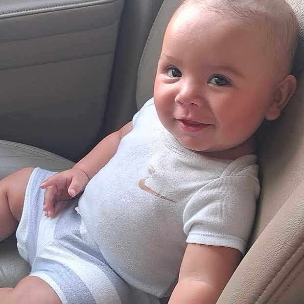 Atlas joined the competition — help win amazing prizes! baby, child, infant, smiling, happy, portrait, sitting, car, car_seat, vehicle_interior, outdoor_trip, clothing, onesie, shorts, face, eyes, head, arms, legs, photography