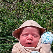Atlas is registered to the contest to win money with this photo: newborn, baby, infant, sleeping, outdoors, grass, plants, nature, sun_hat, pink_clothing, blanket, cuddly, portrait, close_up, face, peaceful, daylight, garden, floral, resting