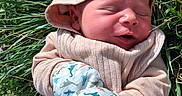 Atlas is registered to the contest to win money with this photo: newborn, baby, child, sleeping, outdoors, grass, garden, hat, scarf, mittens, dinosaur_pattern, winter_clothing, hooded_outfit, portrait, close_up, face, peaceful, nature, sunlight, cozy