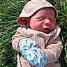 newborn, baby, child, sleeping, outdoors, grass, garden, hat, scarf, mittens, dinosaur_pattern, winter_clothing, hooded_outfit, portrait, close_up, face, peaceful, nature, sunlight, cozy