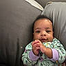 Iyana joined the competition — help win amazing prizes! baby, infant, child, portrait, indoors, couch, cushions, seated, awake, looking_at_camera, hands, clasped_hands, onesie, colorful_clothing, smiling, face, eyes, hair, home, soft_lighting