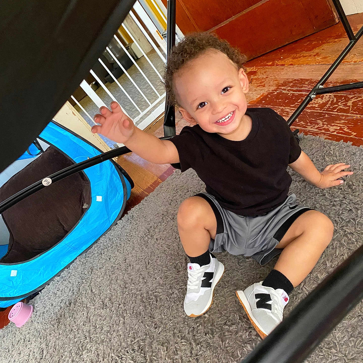 Dionte joined the competition — help win amazing prizes! black_tshirt, blue_play_tent, carpet, casual_clothing, child, curly_hair, floor, gray_shorts, happy, indoor, metal_bars, person, playful, reaching_out, room, smiling, toddler, white_sneakers, wooden_door, young_child