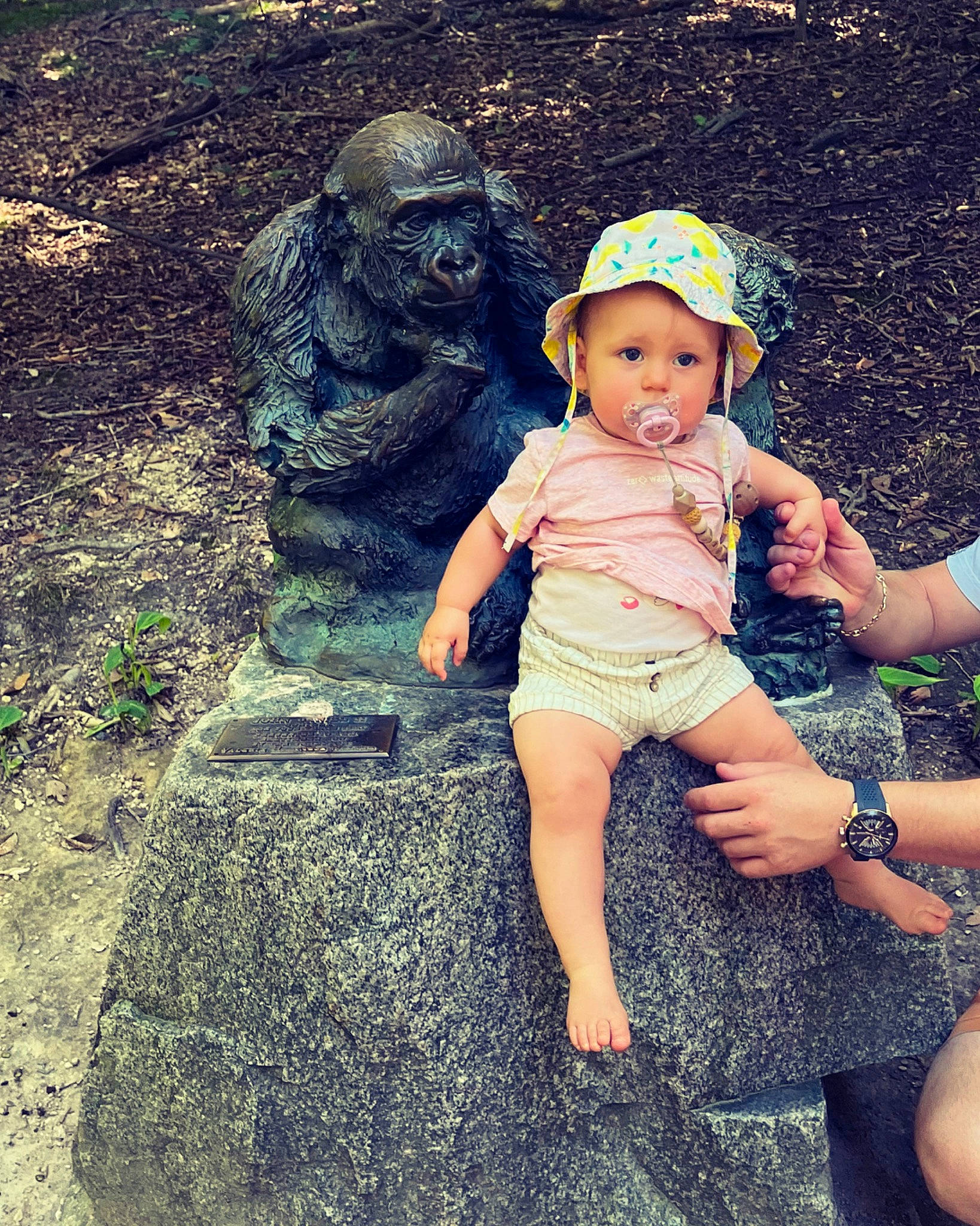Brooke a rejoint le concours — aidez-le/la à gagner de superbes lots ! baby, baseball_cap, cap, foot, fun, grass, happy, hat, headwear, human_leg, landscape, leisure, people_in_nature, person, plant, recreation, sculpture, sitting, sun_hat, t_shirt
