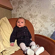 Charlie participe au concours pour gagner de l'argent avec cette photo : baby, infant, armchair, blanket, clothing, footwear, tights, person, portrait, indoor, furniture, patterned_wallpaper, cute, sitting, looking, cozy, decor, small_shoes, black_outfit, white_tights