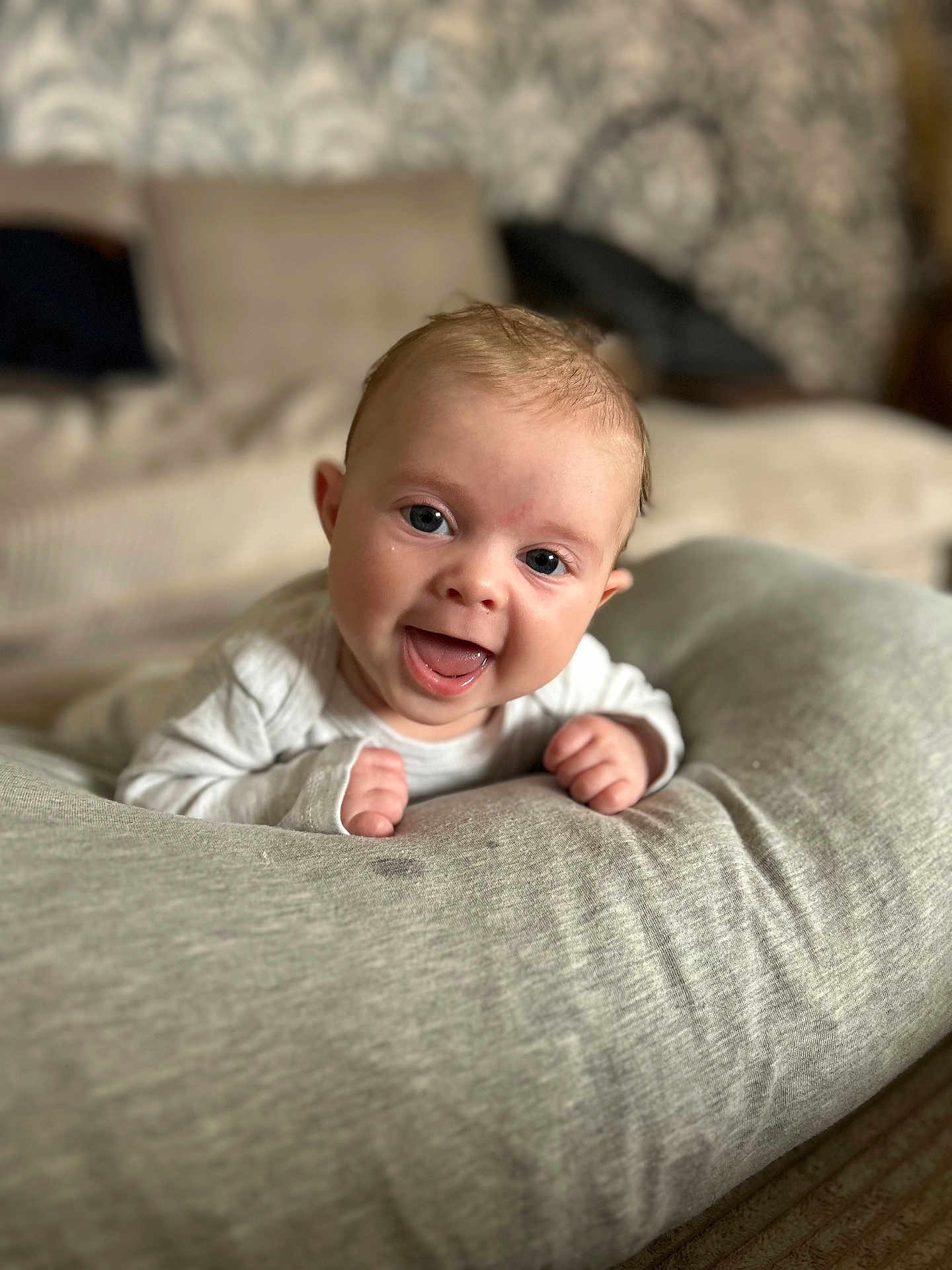 Charlie a rejoint le concours — aidez-le/la à gagner de superbes lots ! baby, smiling, happy, infant, face, cushion, cozy, indoors, cute, child, person, portrait, soft, warm, eyes, hands, clothing, expression, head, young