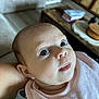 Charlie participe au concours pour gagner de l'argent avec cette photo : baby, books, closeup, clothing, curious, expression, eyes, face, furniture, head, home, human, indoor, infant, person, pink_bib, portrait, skin, table, young_child