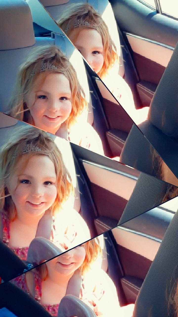 Ashlynn is registered to the contest to win money with this photo: auto_part, blond, car_seat, child, daughter, family_car, fun, joy, person, reading, seat_belt, smile, vehicle_door