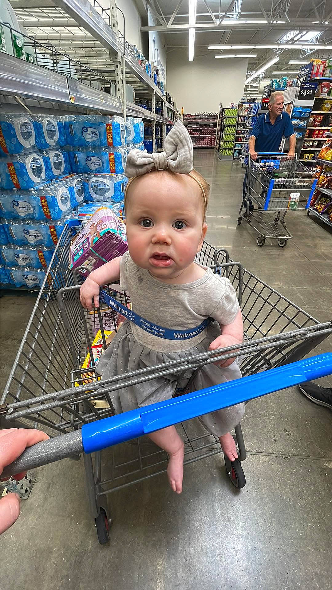 Skylar is registered to the contest to win money with this photo: baby, blue, cart, child, electric_blue, fun, human_leg, human_settlement, leisure, mammal, person, play, product, retail, shelf, shopping, shopping_cart, shorts, sitting, standing