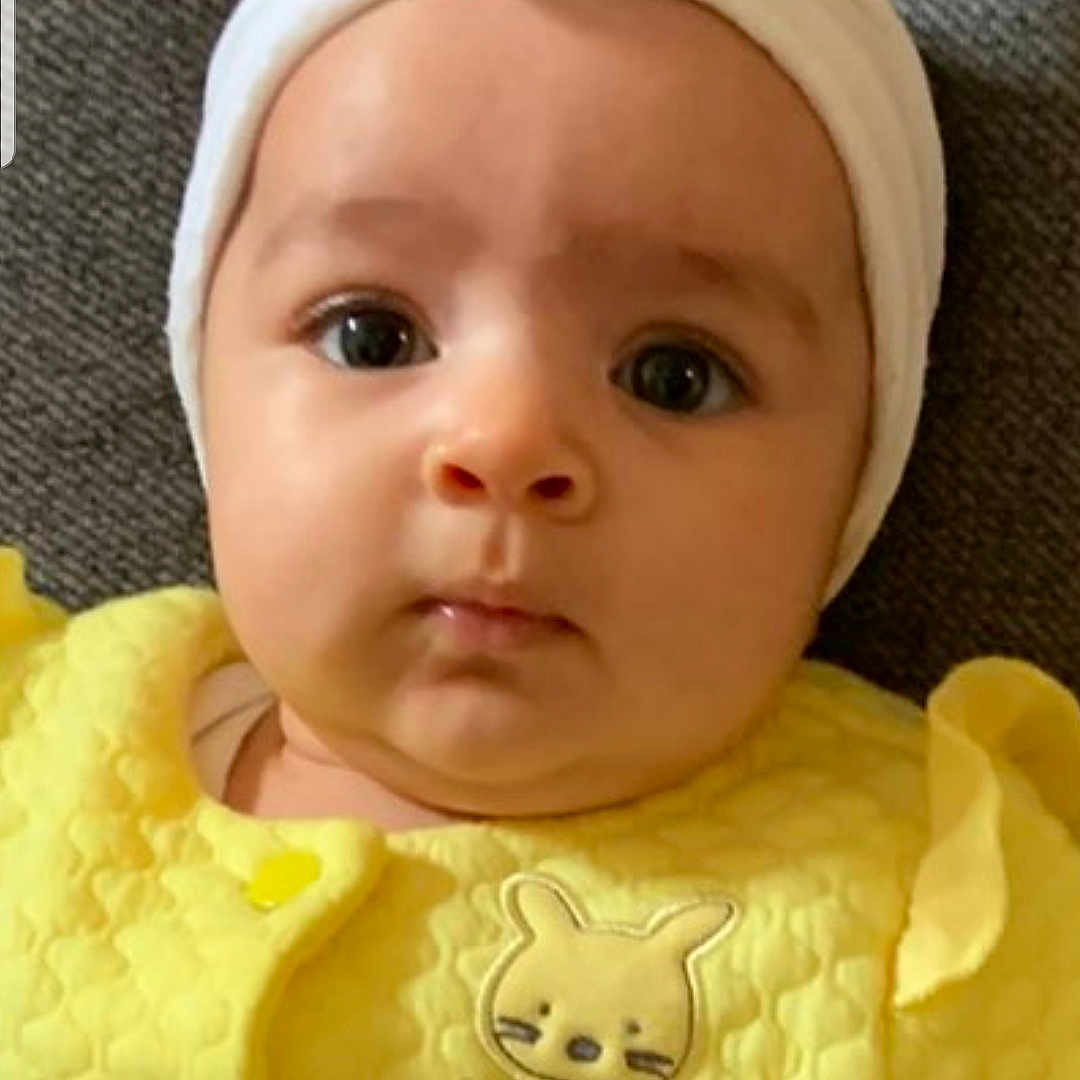 Naïsmée participe au concours pour gagner de l'argent avec cette photo : baby, bunny_patch, child, closeup, cute, expression, eyes, fabric, face, flower, headband, indoors, infant, lying_down, portrait, skin, soft_lighting, texture, yellow_clothing, young