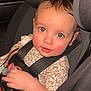 toddler, child, car_seat, safety_harness, pacifier, floral_outfit, curious, rosy_cheeks, indoor, seatbelt, young_child, cute, baby, person, portrait, car_interior, seat, headrest, closeup, infant