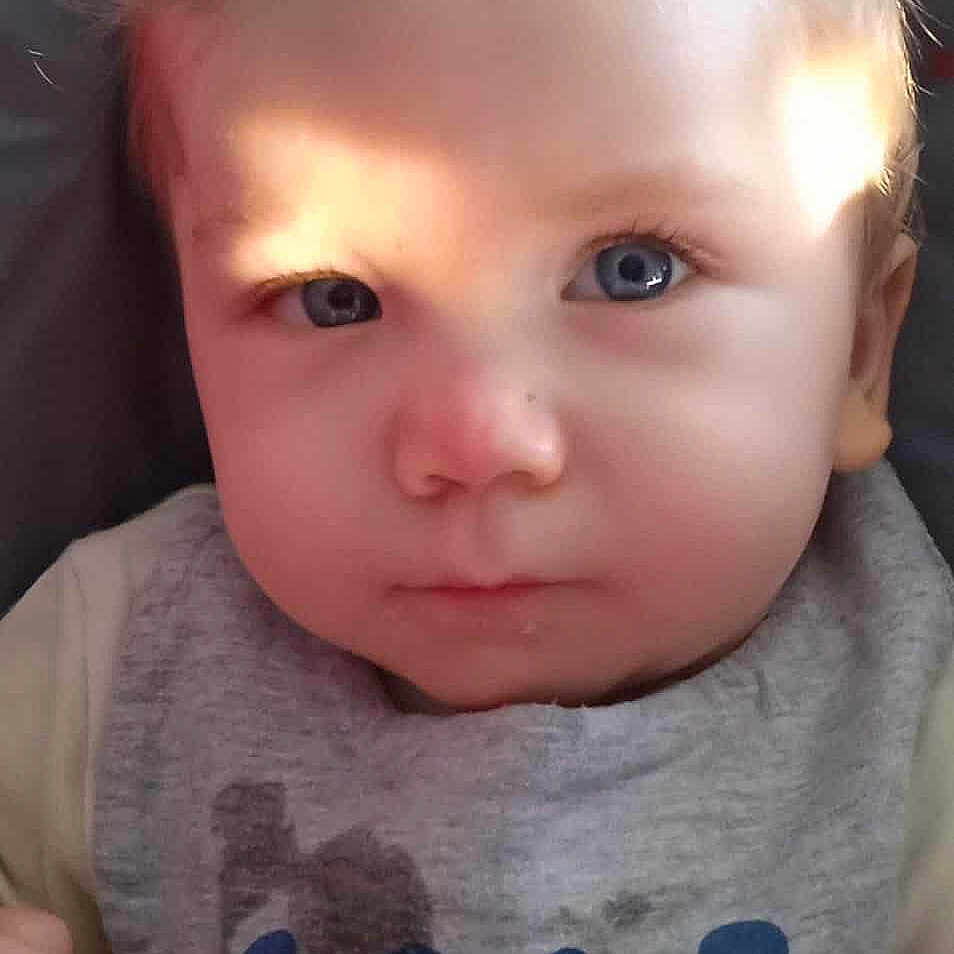 Graham participe au concours pour gagner de l'argent avec cette photo : baby, bib, blue_eyes, child, closeup, clothing, cute, expression, face, head, indoor, infant, light, natural_light, person, portrait, serious, sitting, skin, young_child