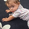 Aliyah is registered to the contest to win money with this photo: baby, toddler, child, crawling, portrait, face, eyes, hair, hair_clip, looking_at_camera, curious, indoor, playroom, play_mat, wooden_toys, flowers, floral_pattern, clothing, sitting, safe