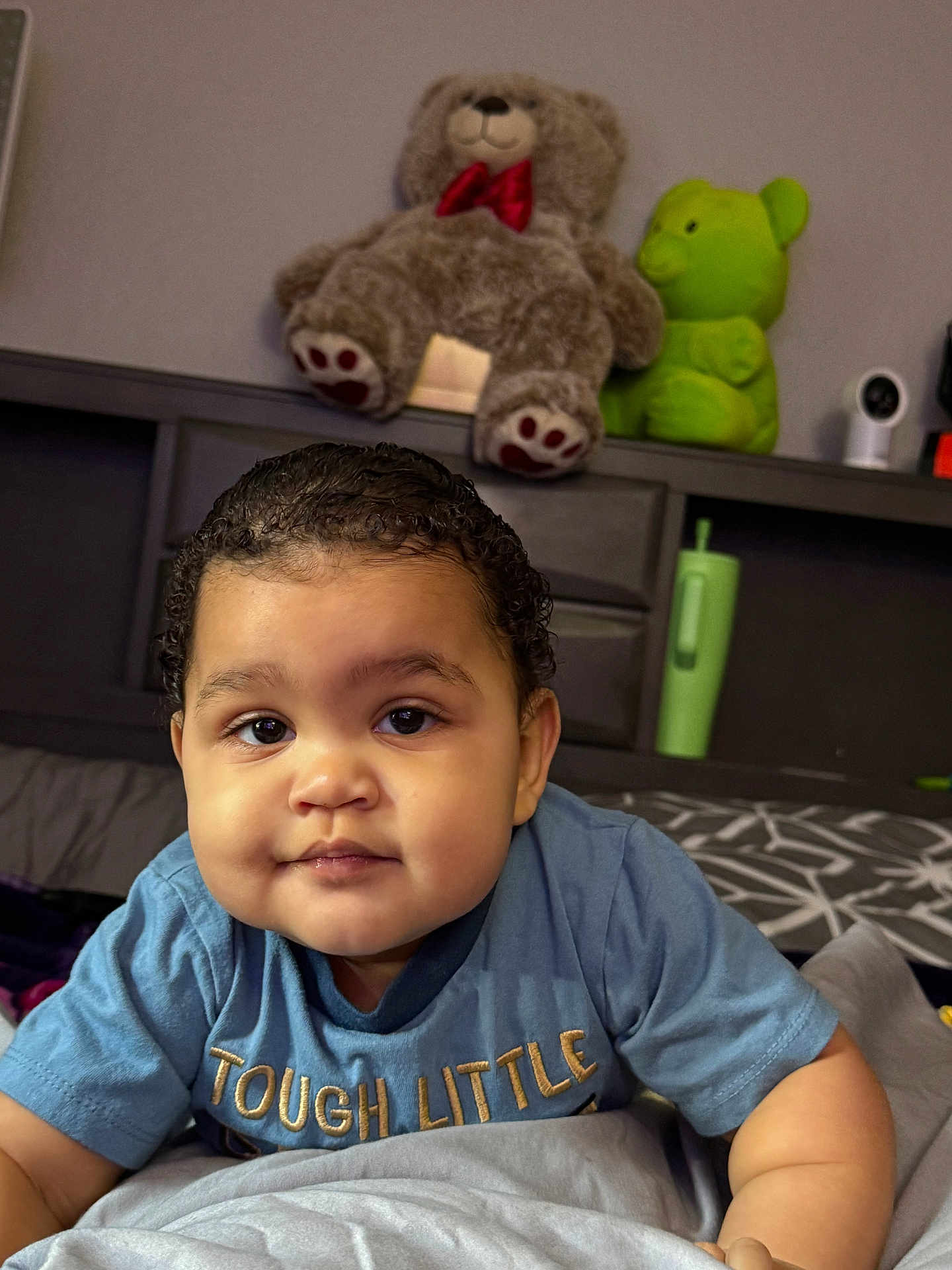 Harlem joined the competition — help win amazing prizes! baby, infant, toddler, child, face, portrait, teddy_bear, plush_toy, green_toy, bed, bedding, blanket, pillow, shirt, clothing, eyes, hair, smile, indoor, nursery