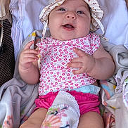 Cataleya participe au concours pour gagner de l'argent avec cette photo : baby, infant, hat, pink_clothing, blanket, stroller, smiling, happy, face, hands, legs, diaper, floral_pattern, child, cute, soft_toys, cozy, relaxed, indoors, portrait