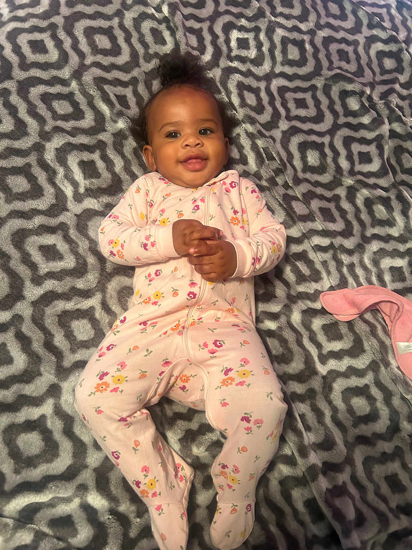 Malanyi is registered to the contest to win money with this photo: baby, infant, child, smiling, onesie, floral_pattern, blanket, cozy, lying_down, happy, cute, indoors, portrait, hands_clasped, footed_pajamas, patterned_blanket, soft_texture, baby_girl, relaxed, sleepwear
