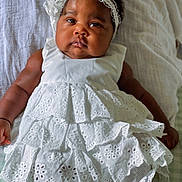 Trycia participe au concours pour gagner de l'argent avec cette photo : baby, infant, white_dress, headband, lying_down, blanket, curly_hair, cute, portrait, child, soft_lighting, indoors, closeup, adorable, chubby_cheeks, fashion, knitted_socks, laying, expression, baby_girl