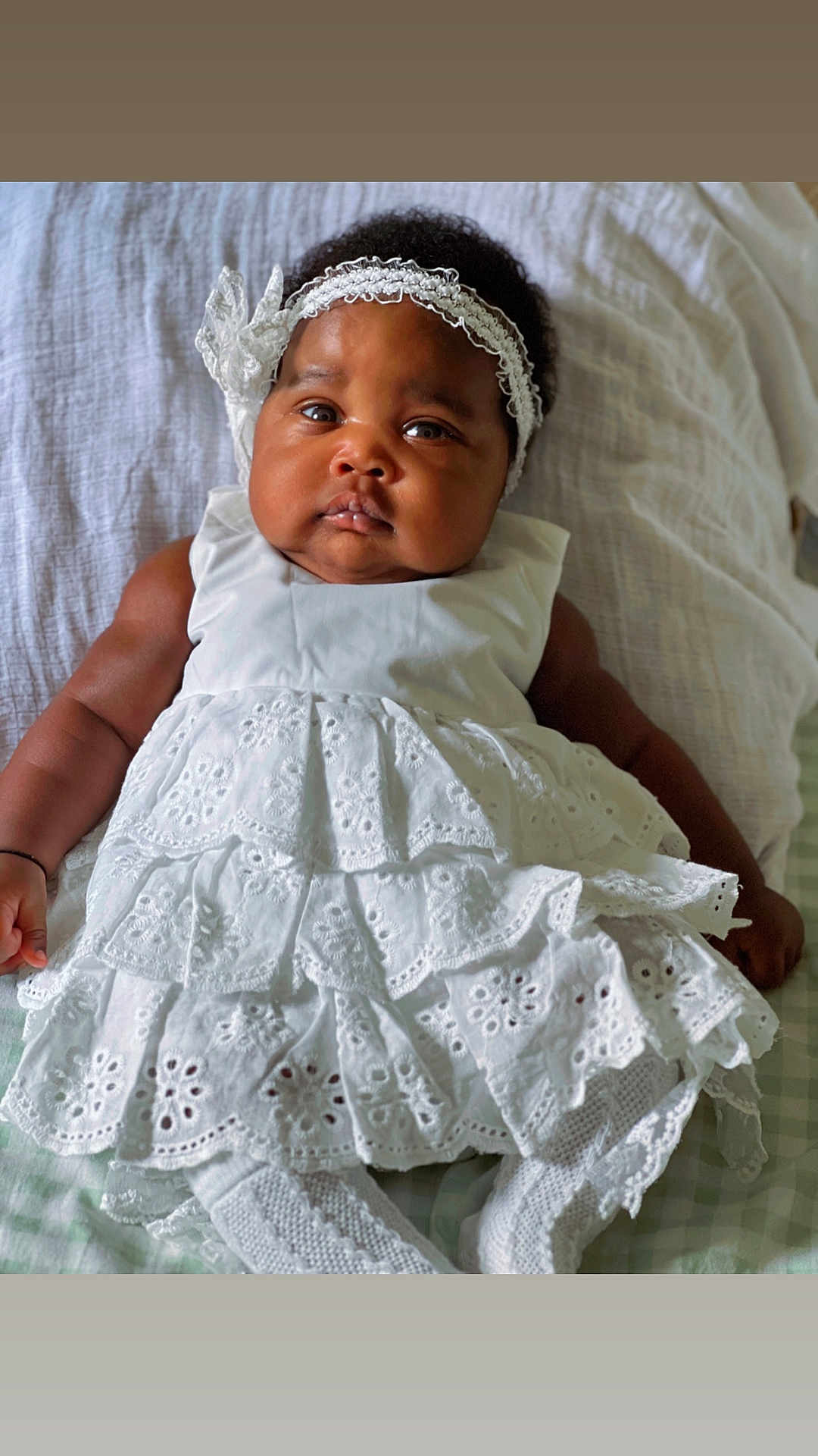 Trycia participe au concours pour gagner de l'argent avec cette photo : baby, infant, white_dress, headband, lying_down, blanket, curly_hair, cute, portrait, child, soft_lighting, indoors, closeup, adorable, chubby_cheeks, fashion, knitted_socks, laying, expression, baby_girl