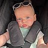 baby, infant, car_seat, sunglasses, blue_eyes, child, seatbelt, safety, cute, portrait, face, expression, clothing, straps, headwear, young_child, indoors, person, skin, seat