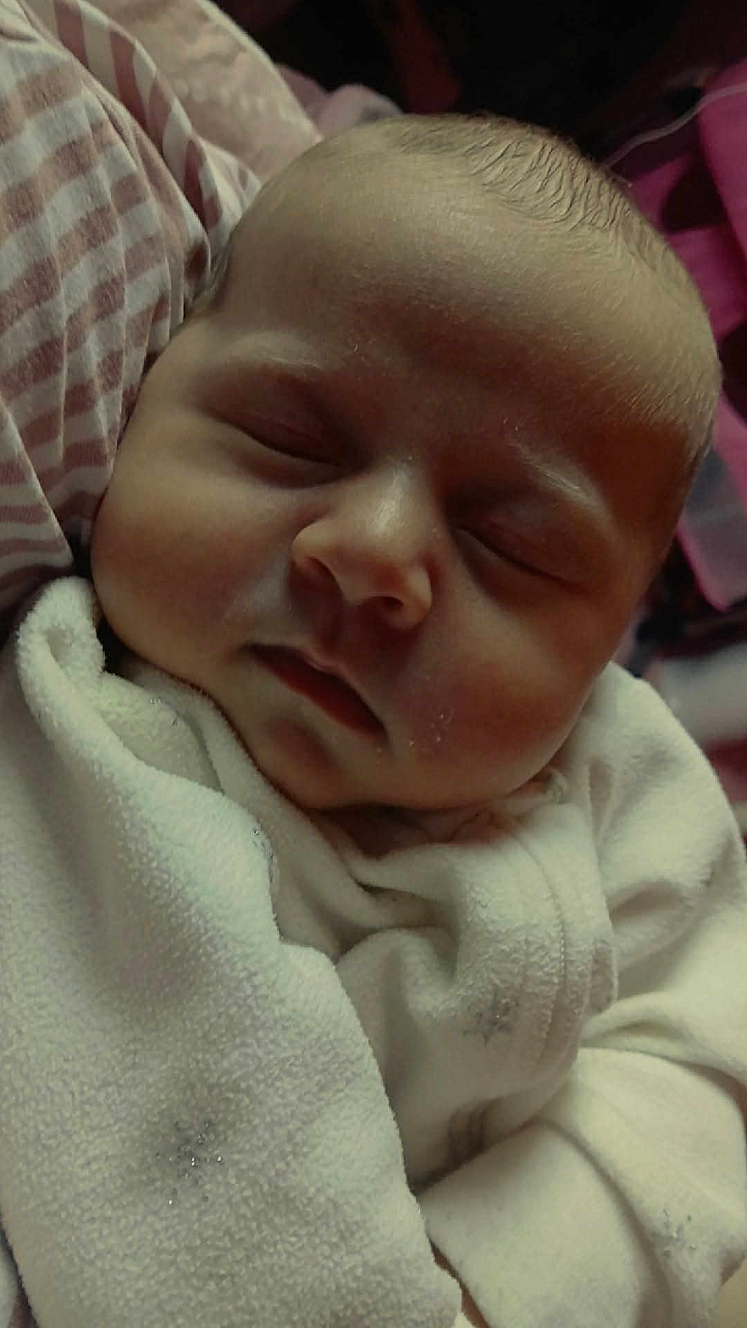 Kalia is registered to the contest to win money with this photo: baby, newborn, sleeping, infant, swaddled, blanket, close_up, portrait, face, closed_eyes, cheeks, nose, lips, head, cozy, soft_texture, fabric, striped_pillow, peaceful, indoors