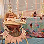 Luna'Rae joined the competition — help win amazing prizes! baby, high_chair, birthday_crown, banner, ice_cream, pastel_colors, fairy_lights, party, celebration, infant, food, cup, tablecloth, decorations, cone, pink, blue_carpet, smiling, child, indoor