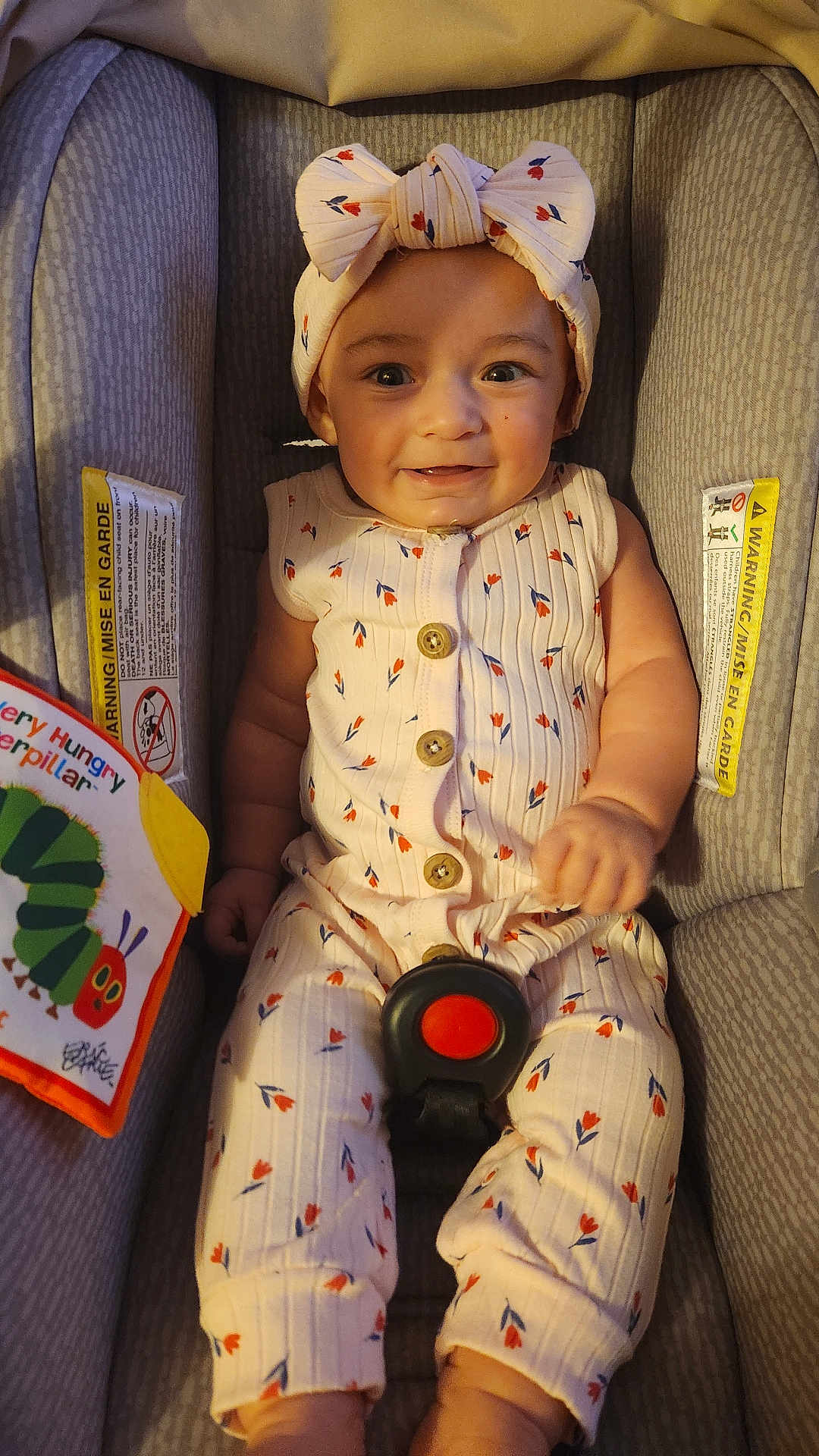 Luna'Rae joined the competition — help win amazing prizes! baby, infant, car_seat, romper, headband, bow, smiling, book, very_hungry_caterpillar, child, cute, patterned_clothing, seatbelt, indoors, portrait, happy, face, sitting, toy, child_reading
