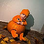 baby, pumpkin, orange_clothing, hat, autumn_leaves, fall, indoor, child, cute, smiling, costume, seasonal, playful, blanket, portrait, holiday, celebration, festive, toddler, cozy