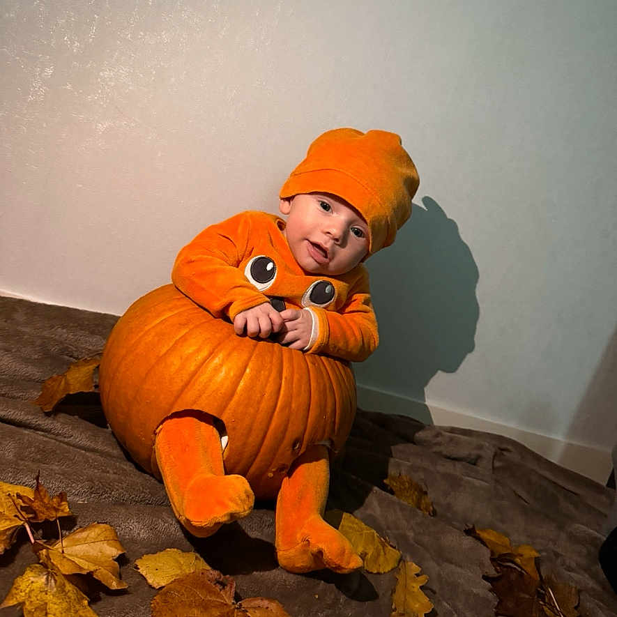 Ezio participe au concours pour gagner de l'argent avec cette photo : autumn_leaves, baby, blanket, celebration, child, costume, cozy, cute, fall, festive, hat, holiday, indoor, orange_clothing, playful, portrait, pumpkin, seasonal, smiling, toddler